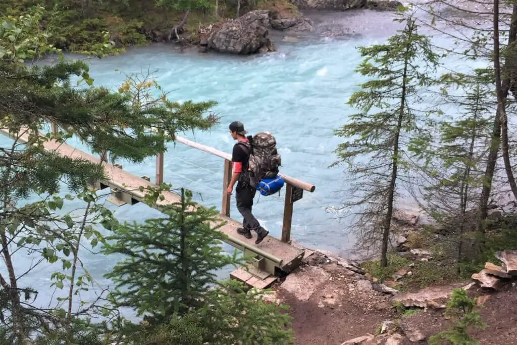 crossing a wooden footbridge on the berg lake trail